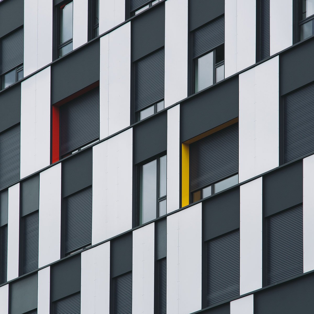 A low angle shot of a black and glass facade of a modern building